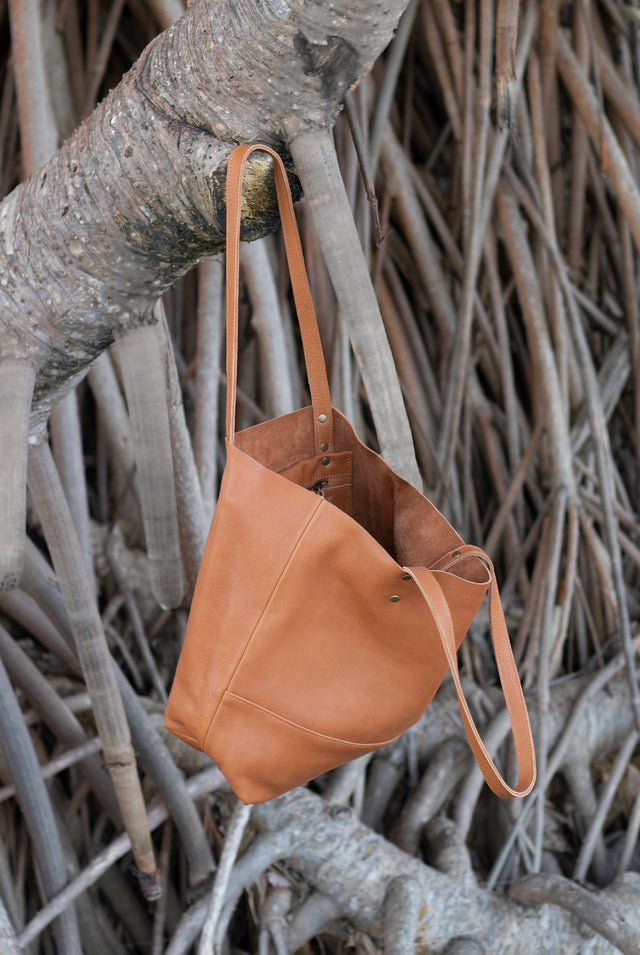 Full grain leather unlined tote bag. It features two interior pockets